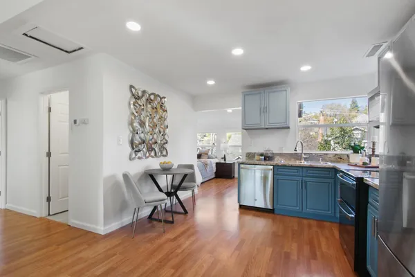 a kitchen with stainless steel appliances granite countertop wooden floors and sink
