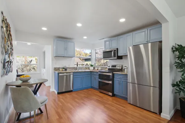 a kitchen with stainless steel appliances granite countertop a refrigerator stove microwave and sink