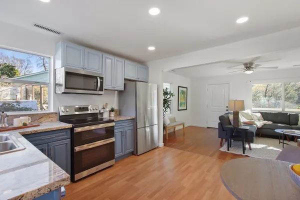 a kitchen with stainless steel appliances granite countertop a refrigerator stove microwave and sink