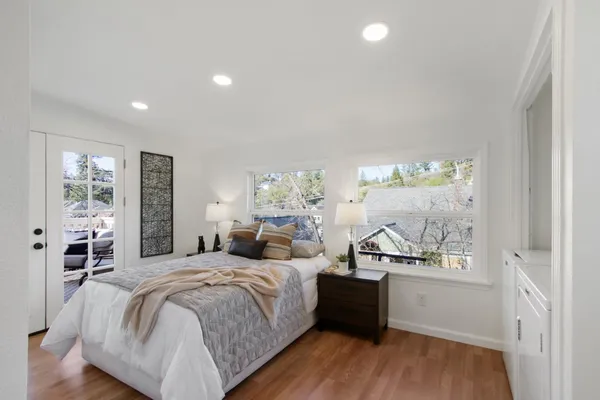 a large bedroom with a bed and wooden floor