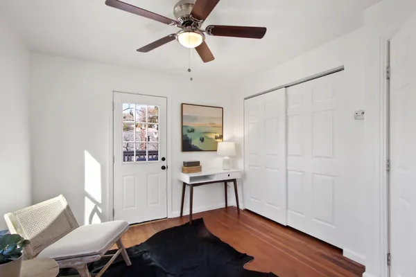 a view of a workspace with furniture and a window