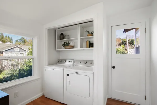 a utility room with cabinets dryer and window