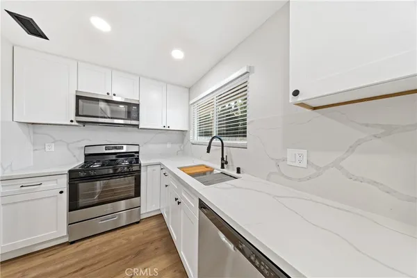 a kitchen with stainless steel appliances granite countertop a sink and stove top oven