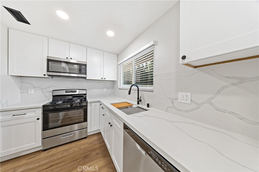 1413 Panorama Ridge Road Oceanside, CA 92056 - Photo 14 of 27 a kitchen with stainless steel appliances granite countertop a sink and stove top oven