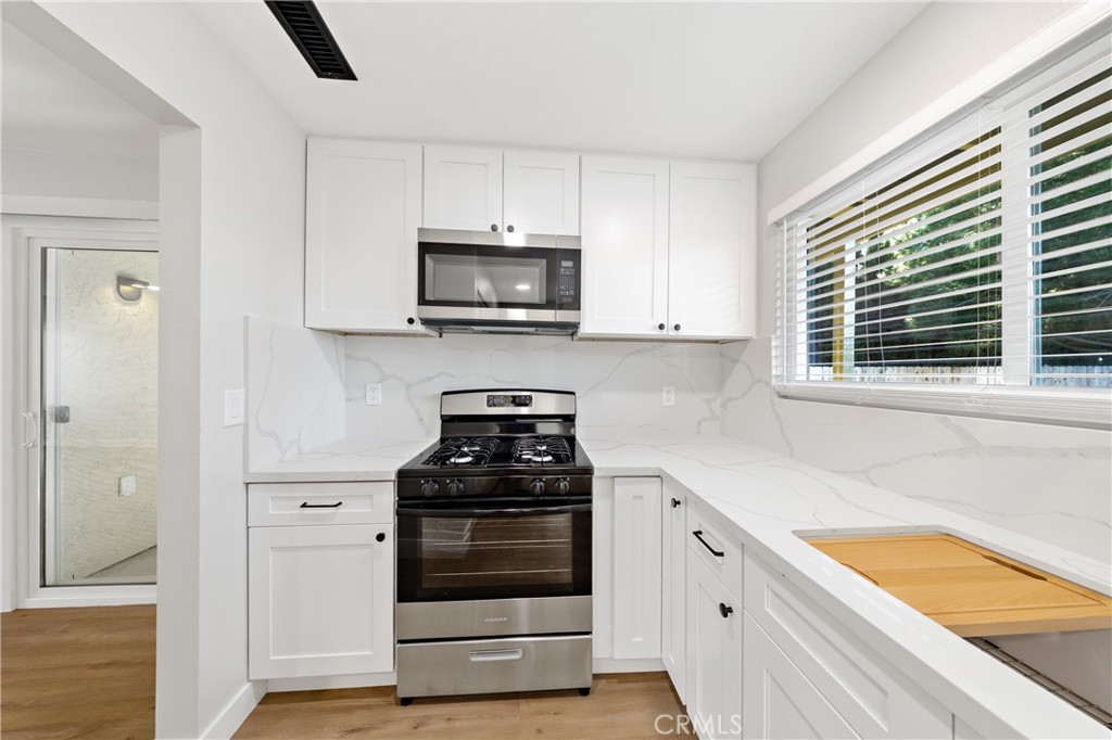 1413 Panorama Ridge Road Oceanside, CA 92056 - Photo 15 of 27 a kitchen with cabinets stainless steel appliances and wooden floor