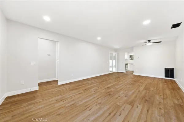 a view of empty room with wooden floor