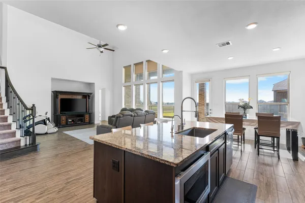a open kitchen with granite countertop a stove dining table and chairs