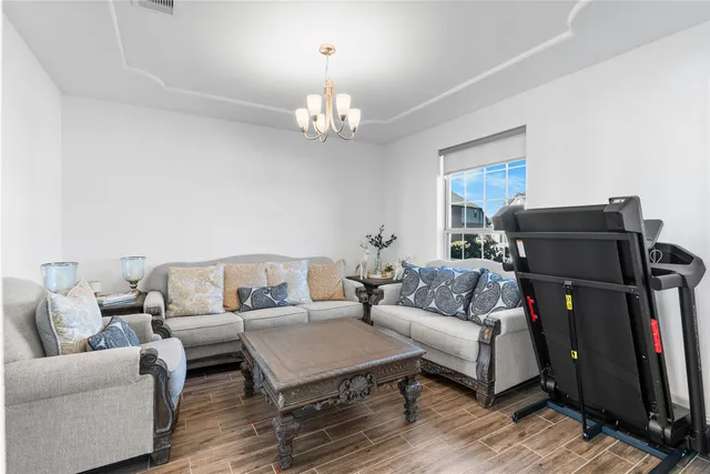 a living room with furniture a fireplace and a chandelier