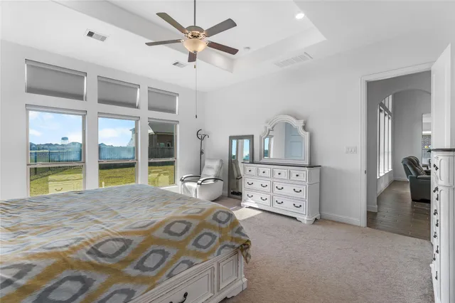 a bedroom with a large bed and a chandelier