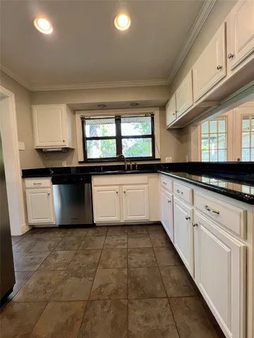 a kitchen with granite countertop a sink stainless steel appliances and cabinets