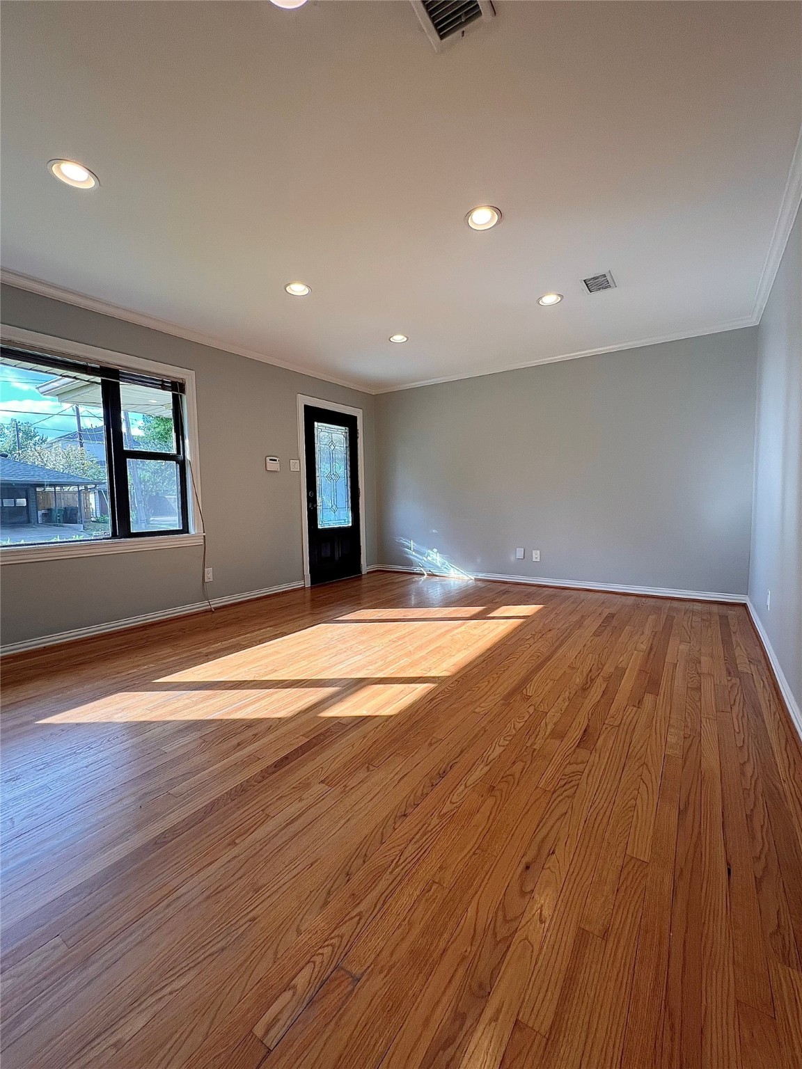 4218 Glebe Road Houston, TX 77018 - Photo 6 of 26 an empty room with wooden floor and windows