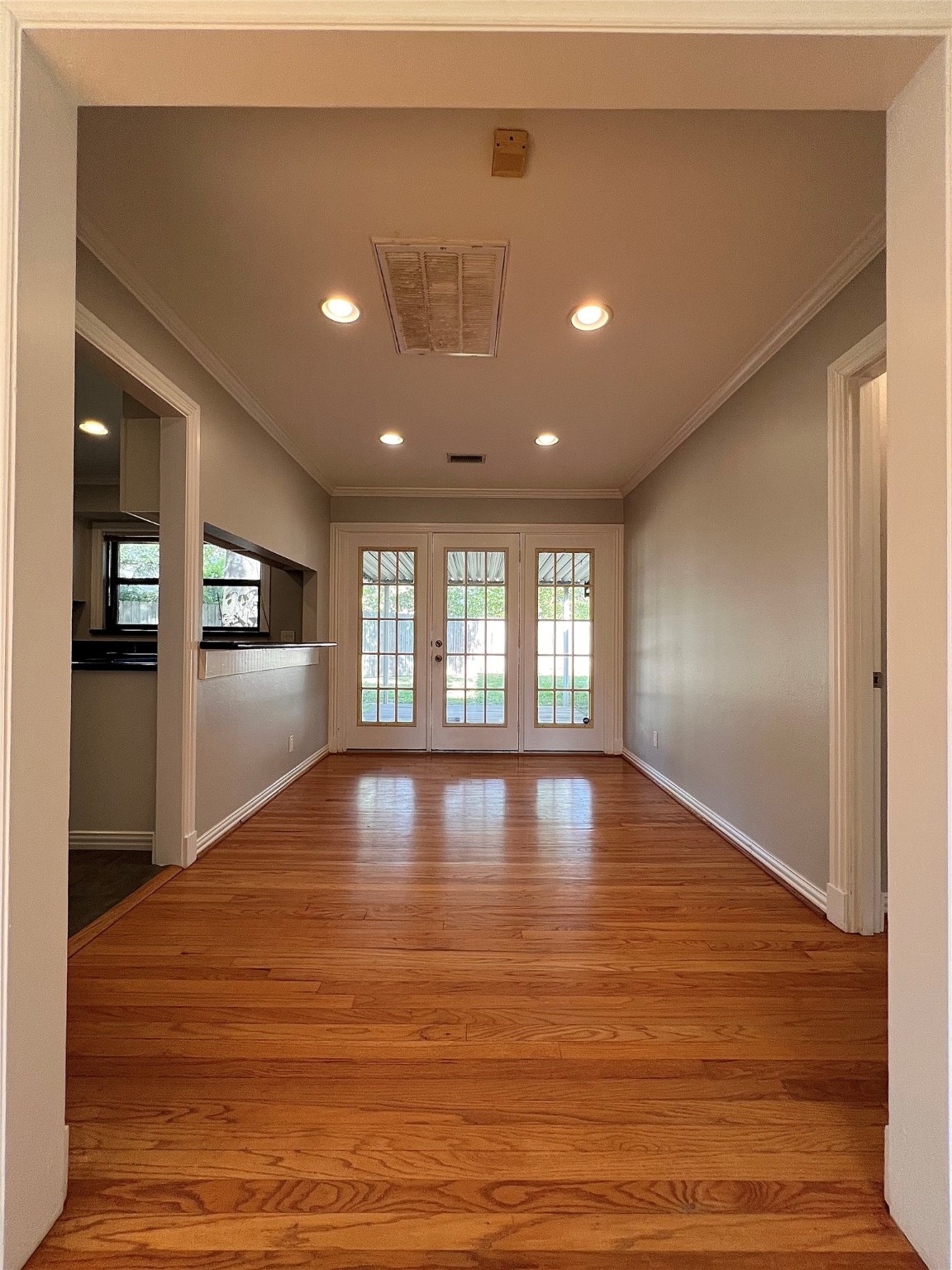 4218 Glebe Road Houston, TX 77018 - Photo 7 of 26 a view of an empty room with wooden floor and a window
