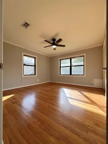 a view of an empty room with wooden floor
