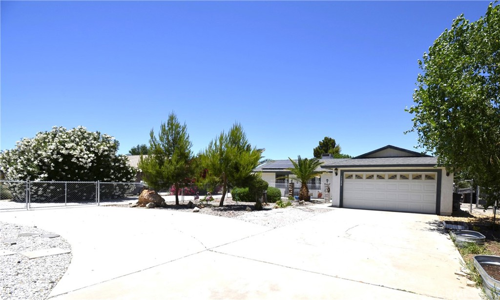 13204 Rancherias Road Apple Valley, CA 92308 - Photo 1 of 1 a front view of a house with a yard and garage