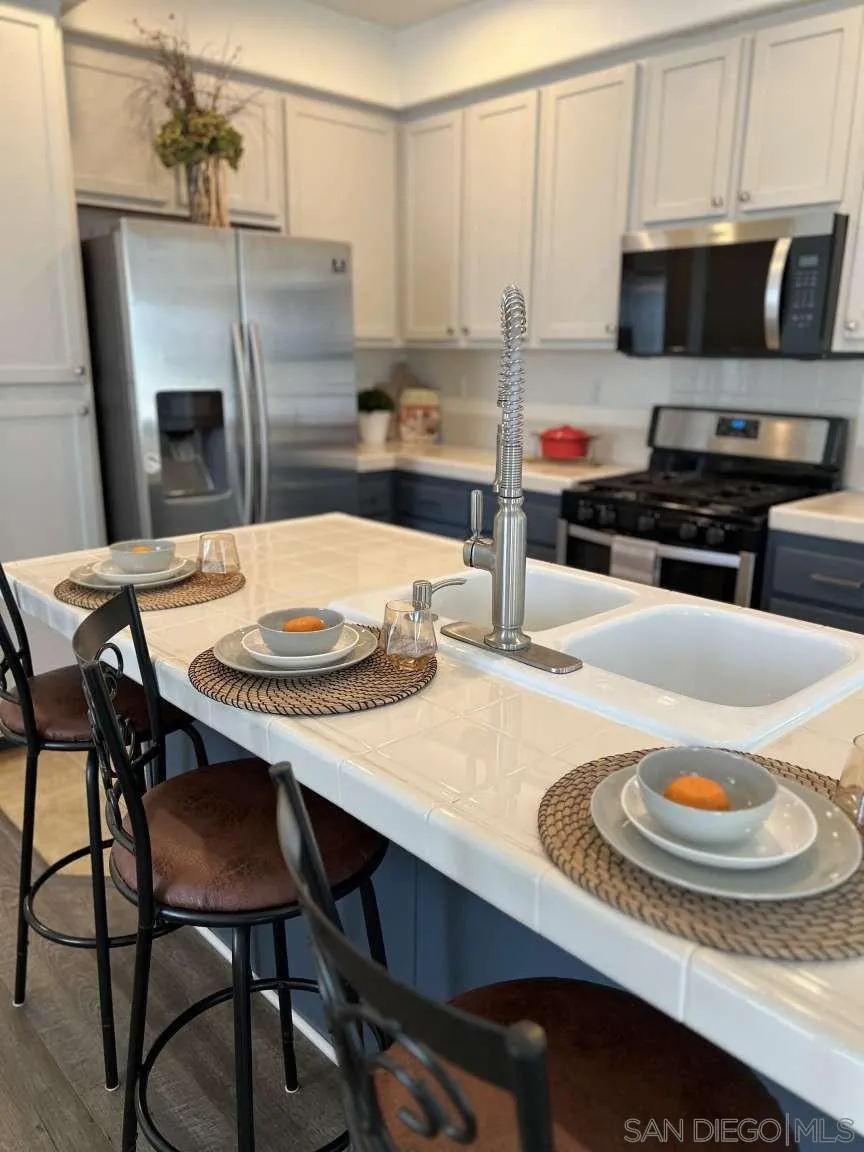 362 Borden Road San Marcos, CA 92069 - Photo 3 of 23 a kitchen with stainless steel appliances a dining table and chairs