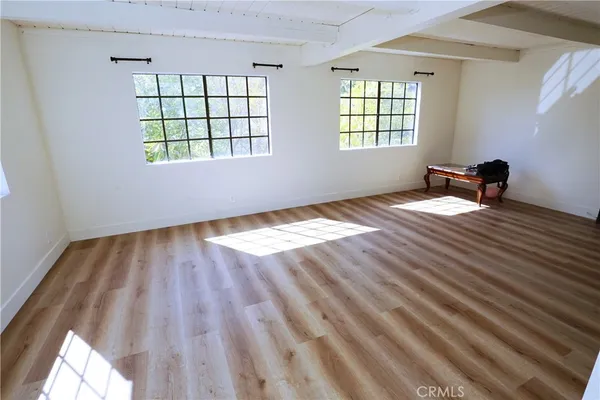 a view of empty room with wooden floor and cabinets