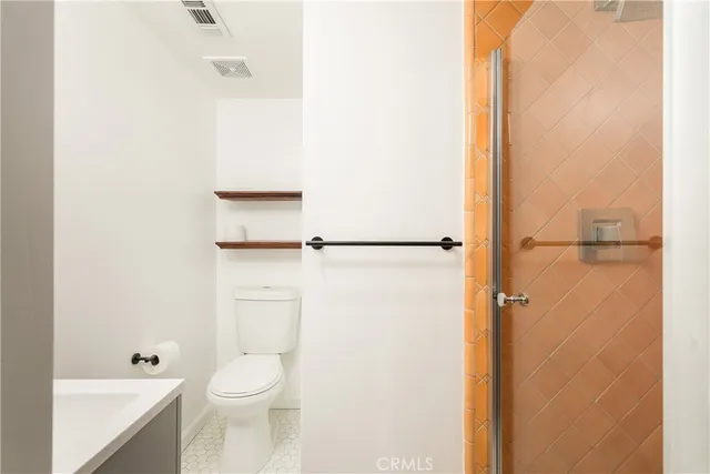 a bathroom with a toilet and a shower