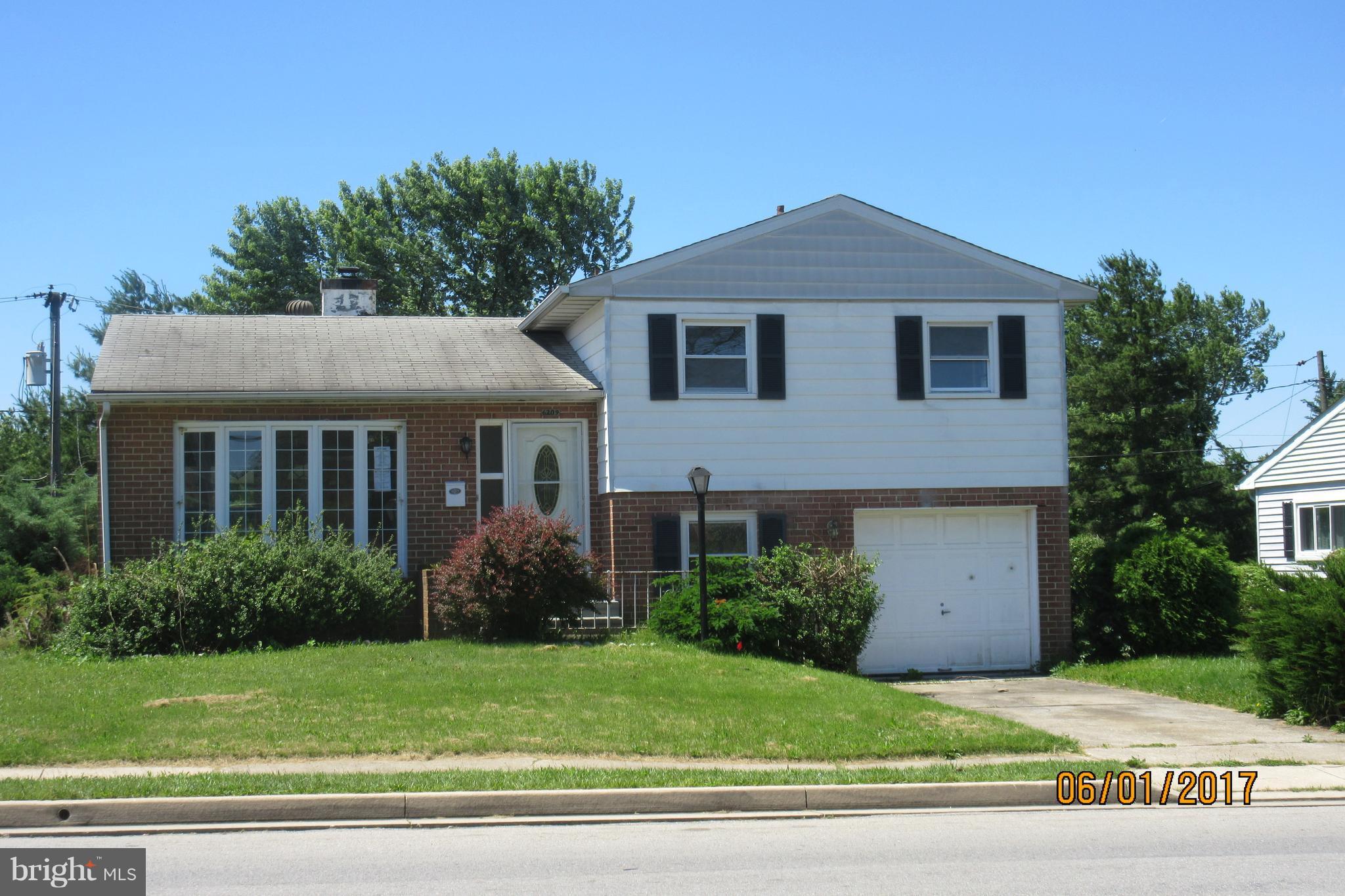 a front view of a house with a yard and trees