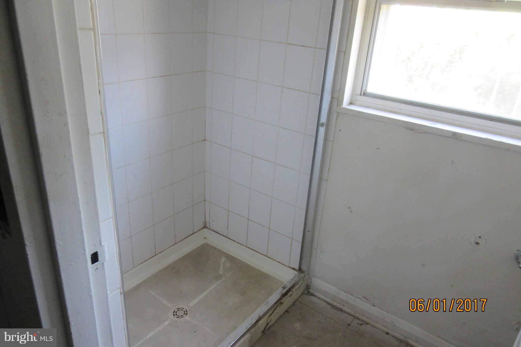 6209 Johnnycake Road Baltimore, MD 21207 - Photo 12 of 15 a bathroom with a glass shower door