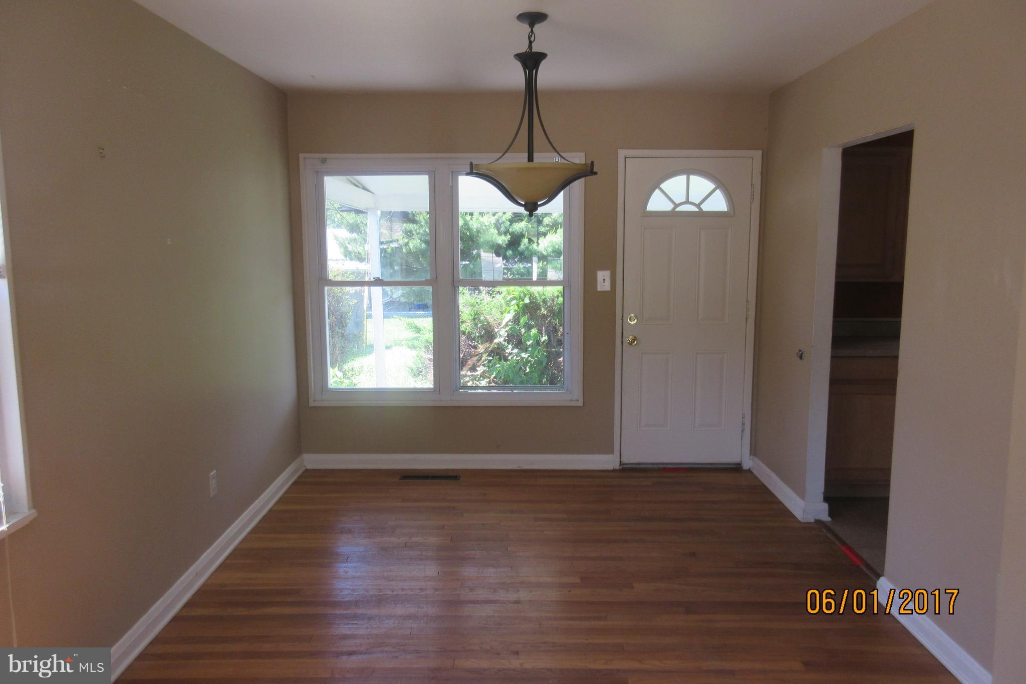 6209 Johnnycake Road Baltimore, MD 21207 - Photo 8 of 15 a view of room with window wooden floor and front door