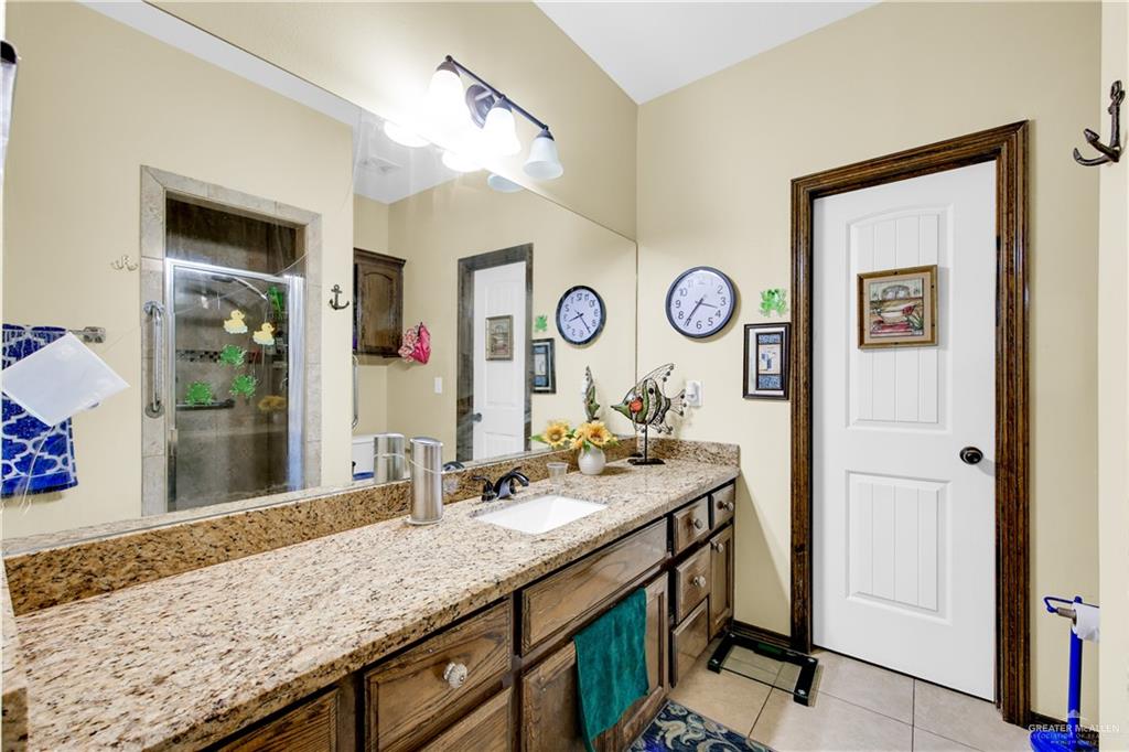814 West 2nd Street Mission, TX 78572 - Photo 12 of 25 a bathroom with a granite countertop sink and a mirror