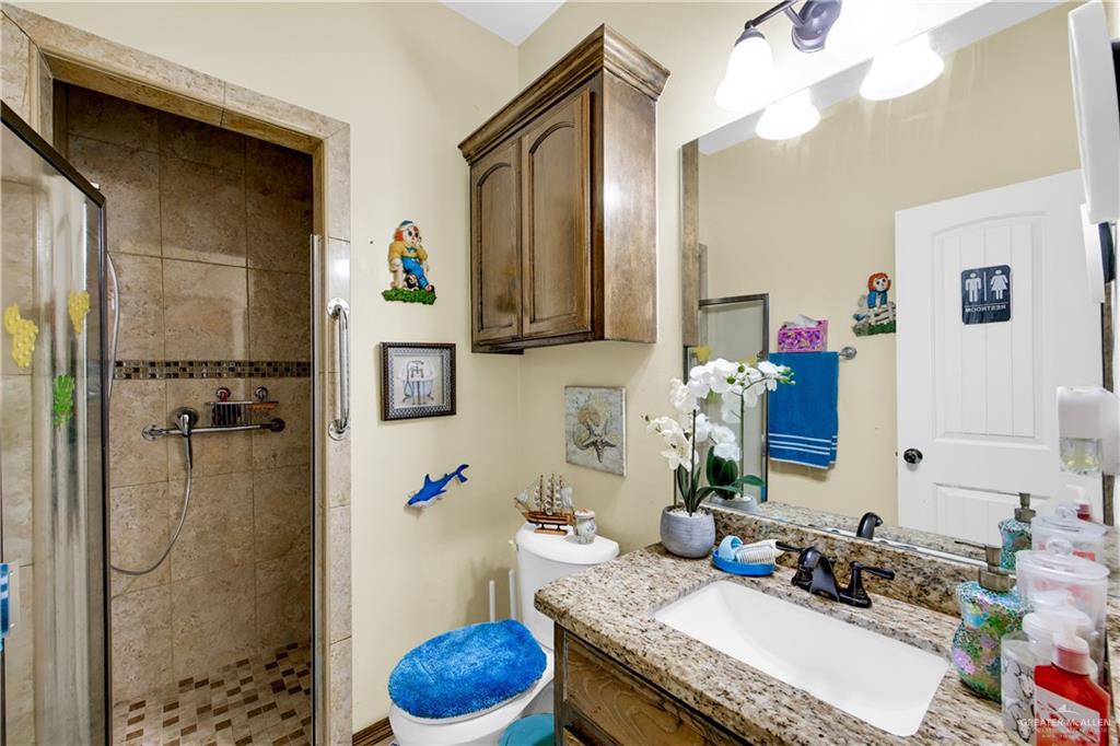 814 West 2nd Street Mission, TX 78572 - Photo 14 of 25 a bathroom with a granite countertop sink and a mirror