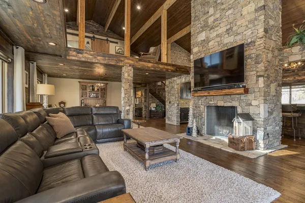a living room with furniture a flat screen tv and a fireplace
