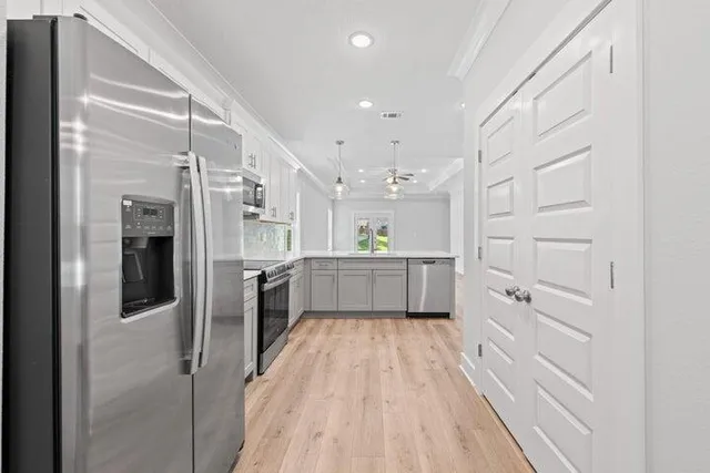 a kitchen with white cabinets and stainless steel appliances
