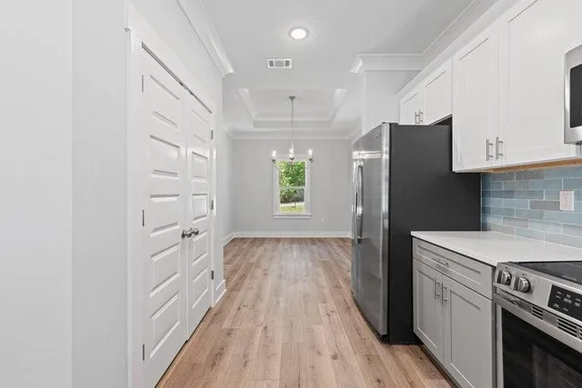 a kitchen with cabinets and wooden floor