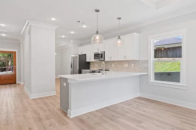 a kitchen with kitchen island a sink stainless steel appliances and cabinets
