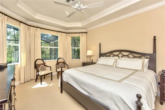 a bedroom with a bed chair and a large window