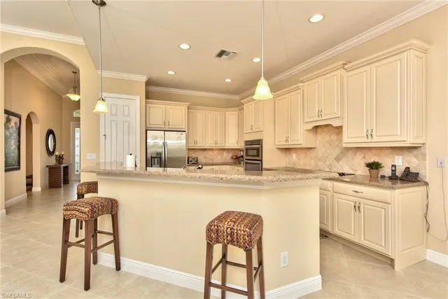 a kitchen with stainless steel appliances granite countertop white cabinets a sink and a stove