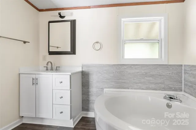 a bathroom with a tub sink and mirror