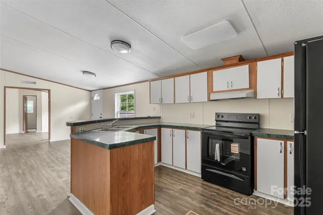 a kitchen with stainless steel appliances granite countertop a stove a sink and a microwave