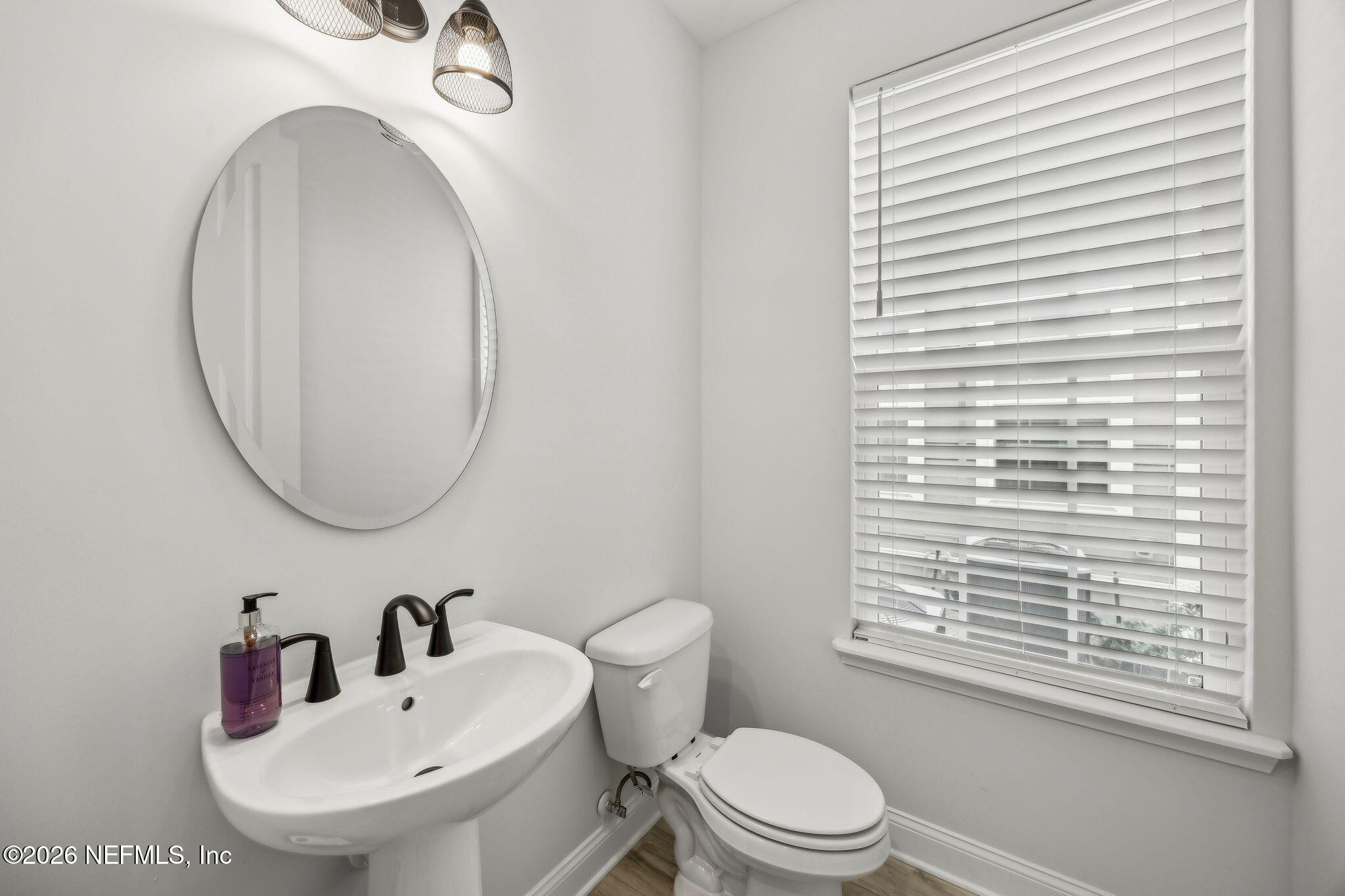 230 Wildlight Avenue Yulee, FL 32097 - Photo 13 of 73 a bathroom with a toilet a sink a mirror and a window