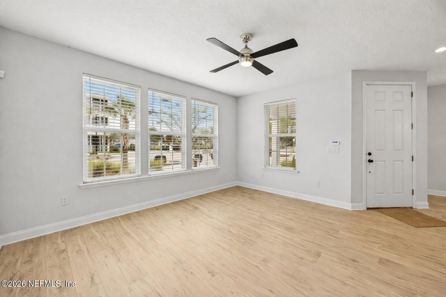230 Wildlight Avenue Yulee, FL 32097 - Photo 5 of 73 a view of an empty room with a window and wooden floor