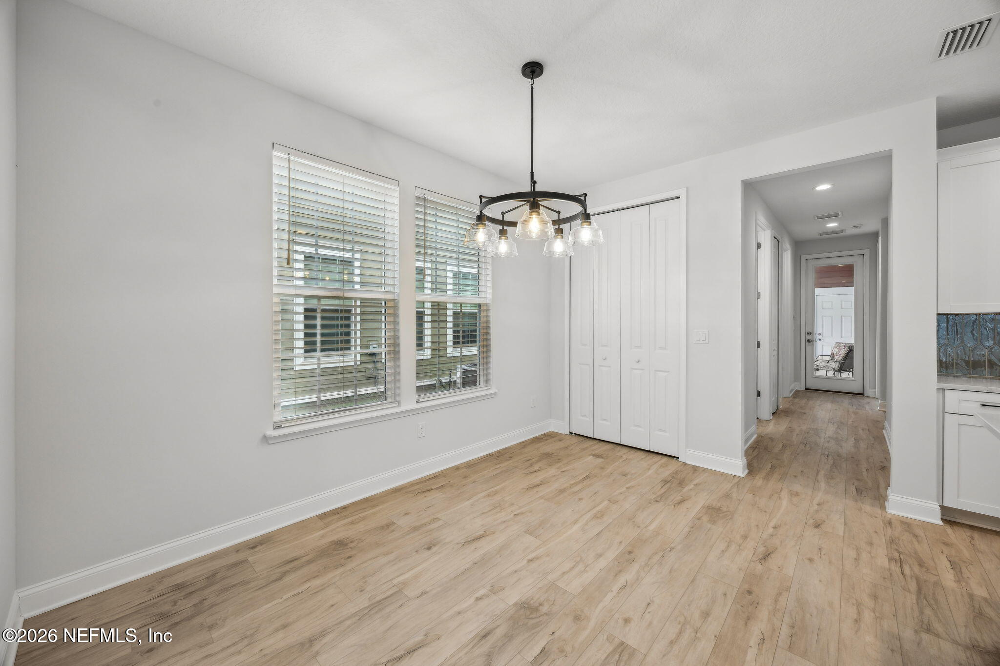 230 Wildlight Avenue Yulee, FL 32097 - Photo 6 of 73 a view of an empty room with wooden floor kitchen view and a window