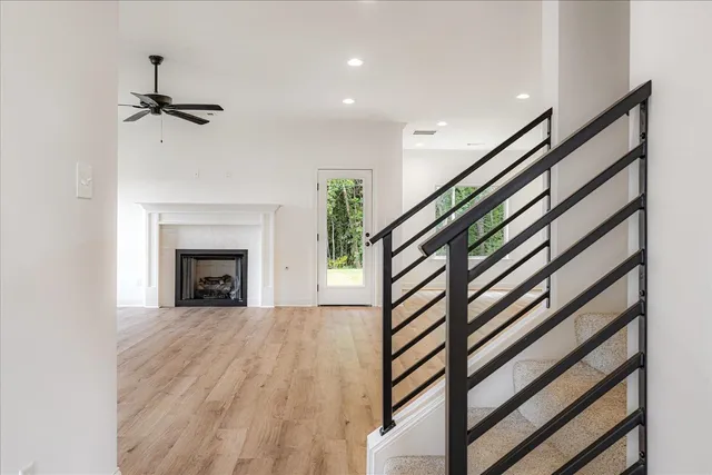 a view of a livingroom with wooden floor and staircase