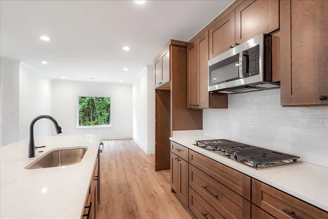 a kitchen with stainless steel appliances a microwave a stove and a sink