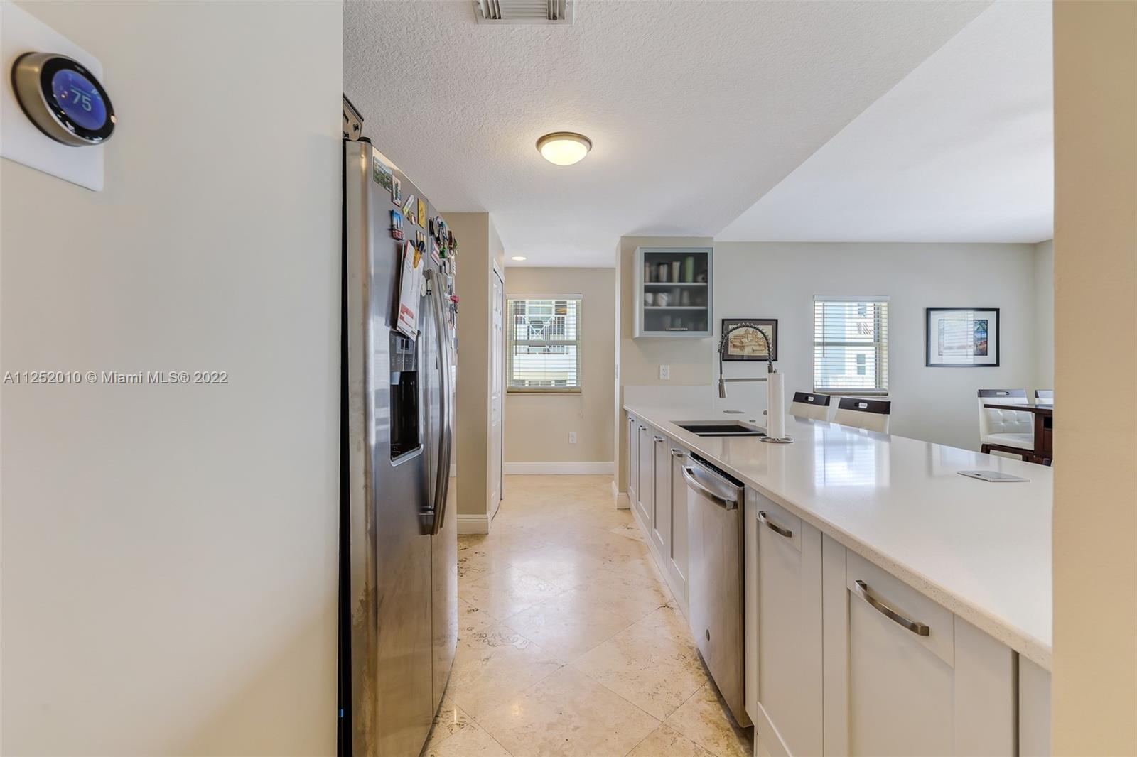 1037 Southwest 9th Court, Unit E1 Miami, FL 33130 - Photo 4 of 26 a kitchen with stainless steel appliances granite countertop a refrigerator and a sink