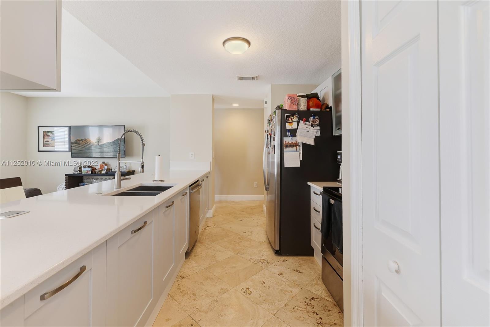 1037 Southwest 9th Court, Unit E1 Miami, FL 33130 - Photo 5 of 26 a kitchen with stainless steel appliances granite countertop a refrigerator and a sink