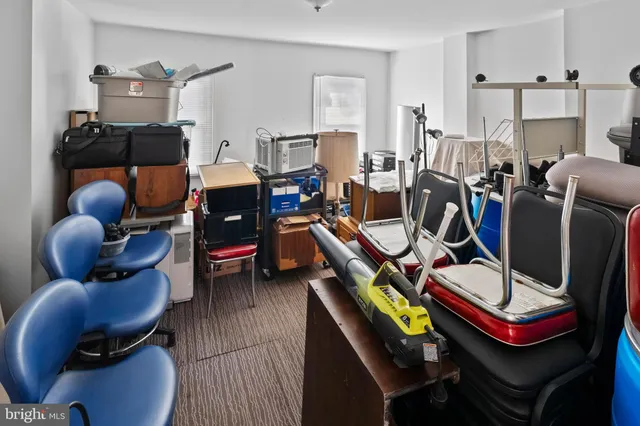a living room with lots of chairs and a dining table with chandelier