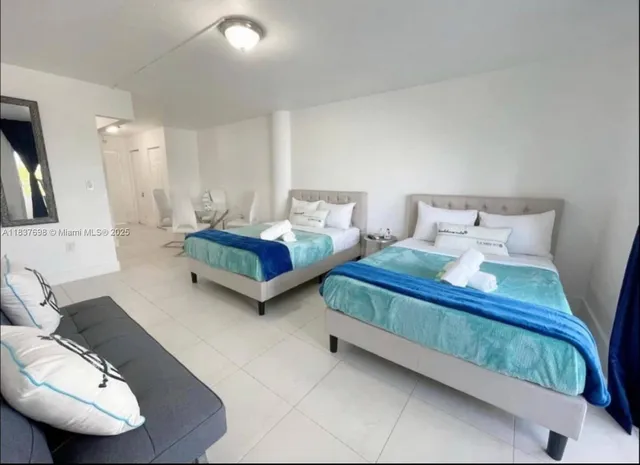 a spacious bedroom with two beds and a couch