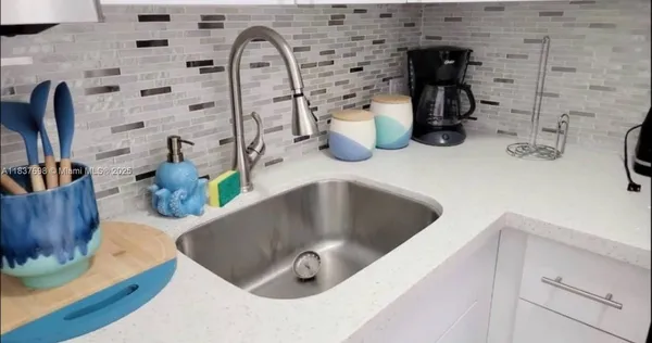 a kitchen with a sink and a wooden floor