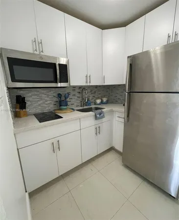 a kitchen with stainless steel appliances granite countertop a refrigerator sink and stove