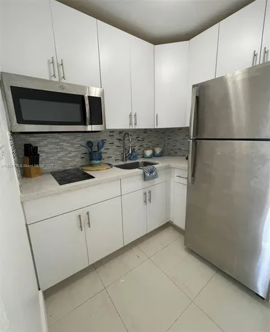 a kitchen with stainless steel appliances granite countertop a refrigerator sink and stove