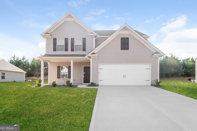 a front view of a house with a yard and garage