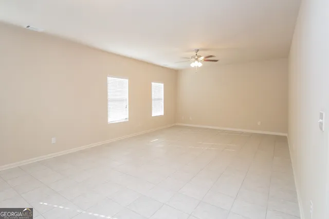 an empty room with a window and a ceiling fan