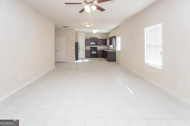 an empty room with windows and a ceiling fan