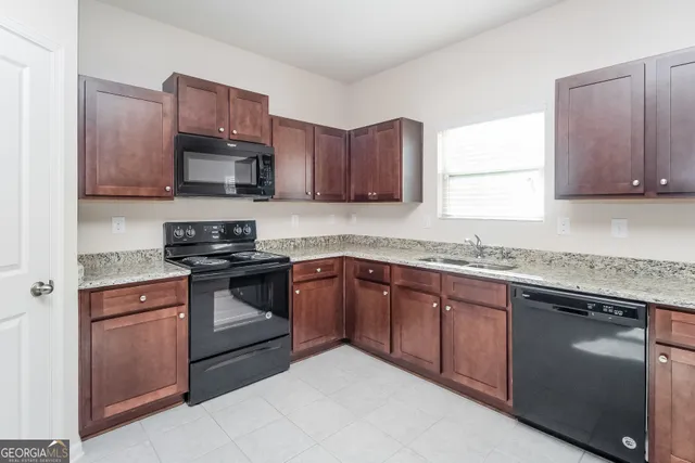 a kitchen with stainless steel appliances granite countertop a sink stove and microwave
